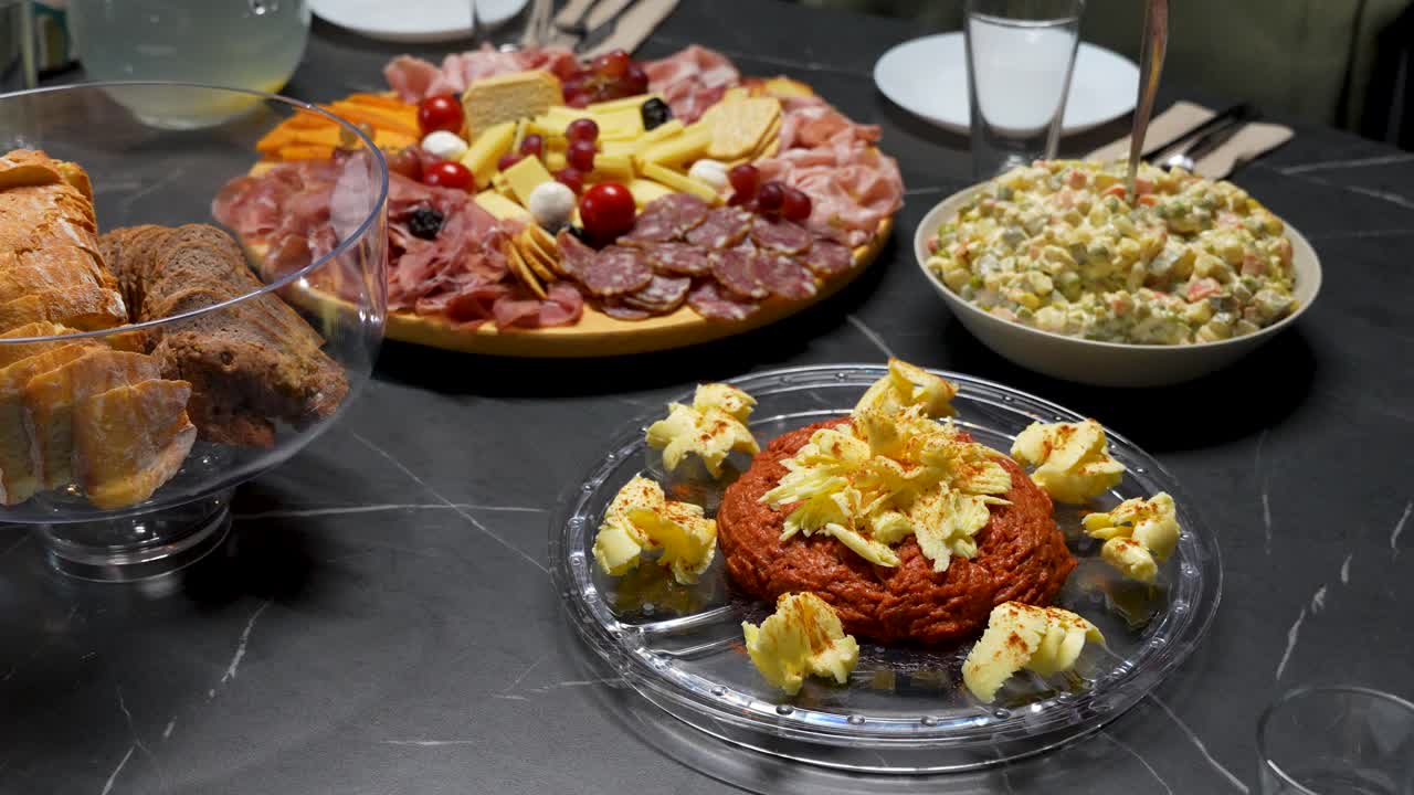 Mesa de cena navideña con tartar de ternera, embutidos, tabla de quesos y ensalada