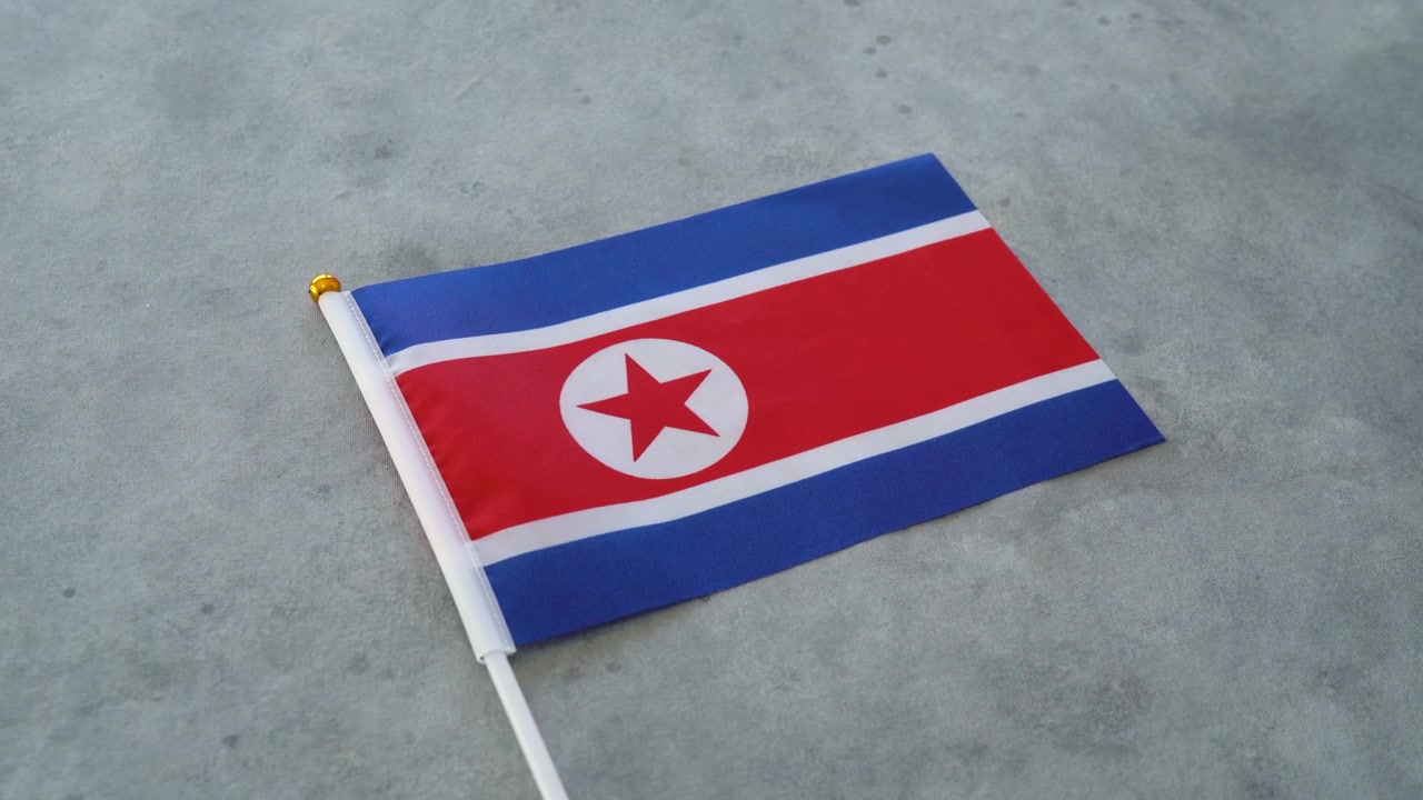Lähikuva Pohjois-Korean miniatyyrilipusta. Pohjois-Korealaista isänmaallisuutta kuvaava konsepti.