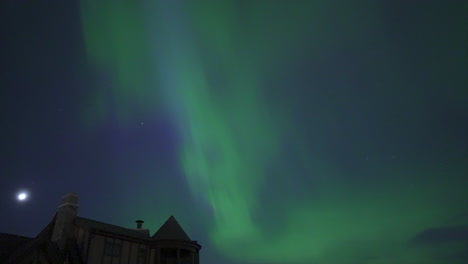 Faszinierendes-Schauspiel-Von-Nordlichtern,-Die-Anmutig-über-Der-Geschäftigen-Skyline-Einer-Stadt-Tanzen-Und-Aurora-Borealis,-Urbane-Landschaft,-Himmlische-Schönheit-Und-Nächtliche-Wunder-Zur-Schau-Stellen