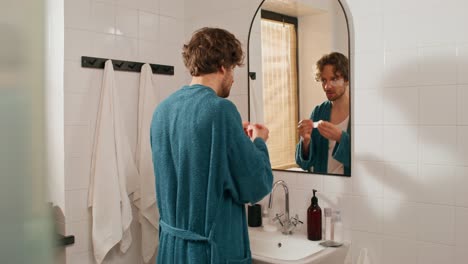 man applying face masks in bathroom