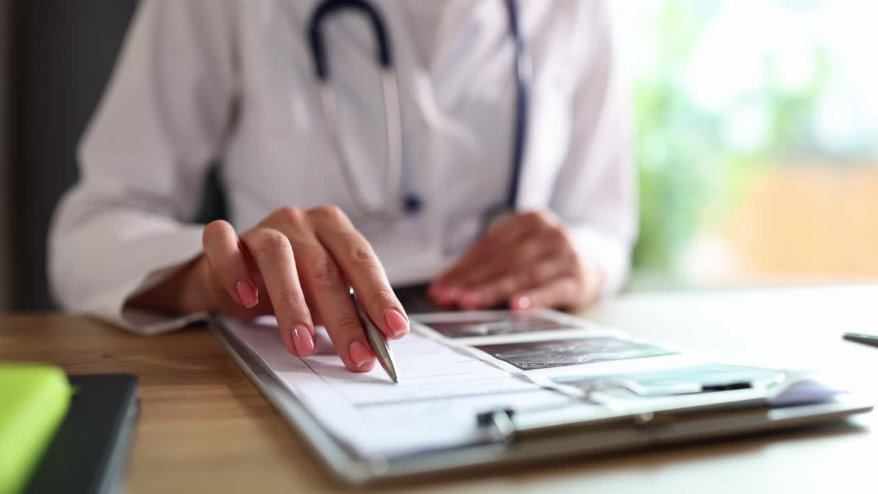 Un medico esamina documenti medici e scansioni a una scrivania
