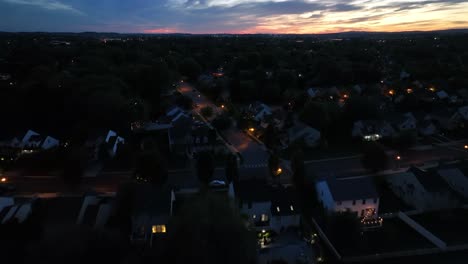 lighting lantern and streetlights in america residential area. one family houses and homes at dusk after sunset. aerial flyover wide shot.
