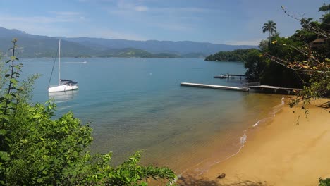 sandy beach and a landing stage with a lonely sailing boat in a lake