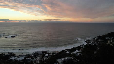 Vista-Al-Océano-Del-Atlántico-Sur-Al-Atardecer-Con-Puesta-De-Sol-En-El-Horizonte-En-Ciudad-Del-Cabo,-Antena