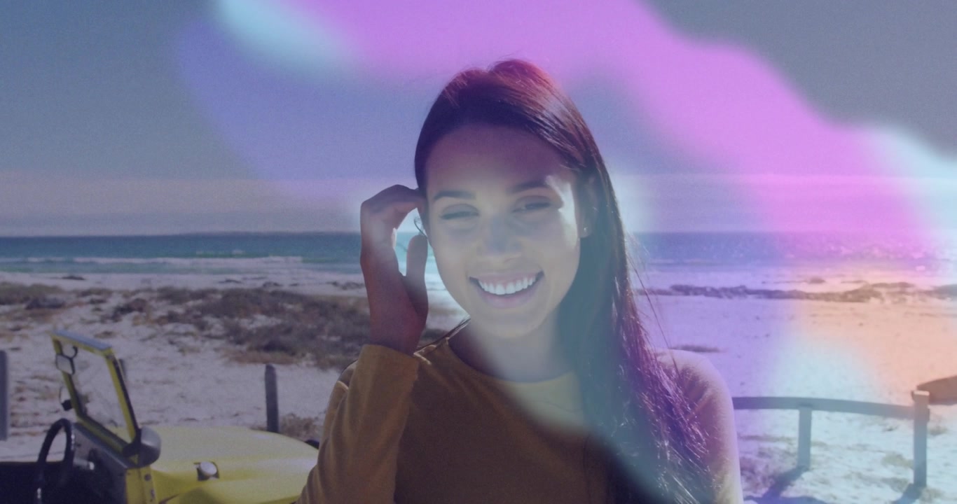 Nebbia viola che si sposta rivelando una donna che regola un auricolare wireless in spiaggia, dimostrando tecnologia di sicurezza
