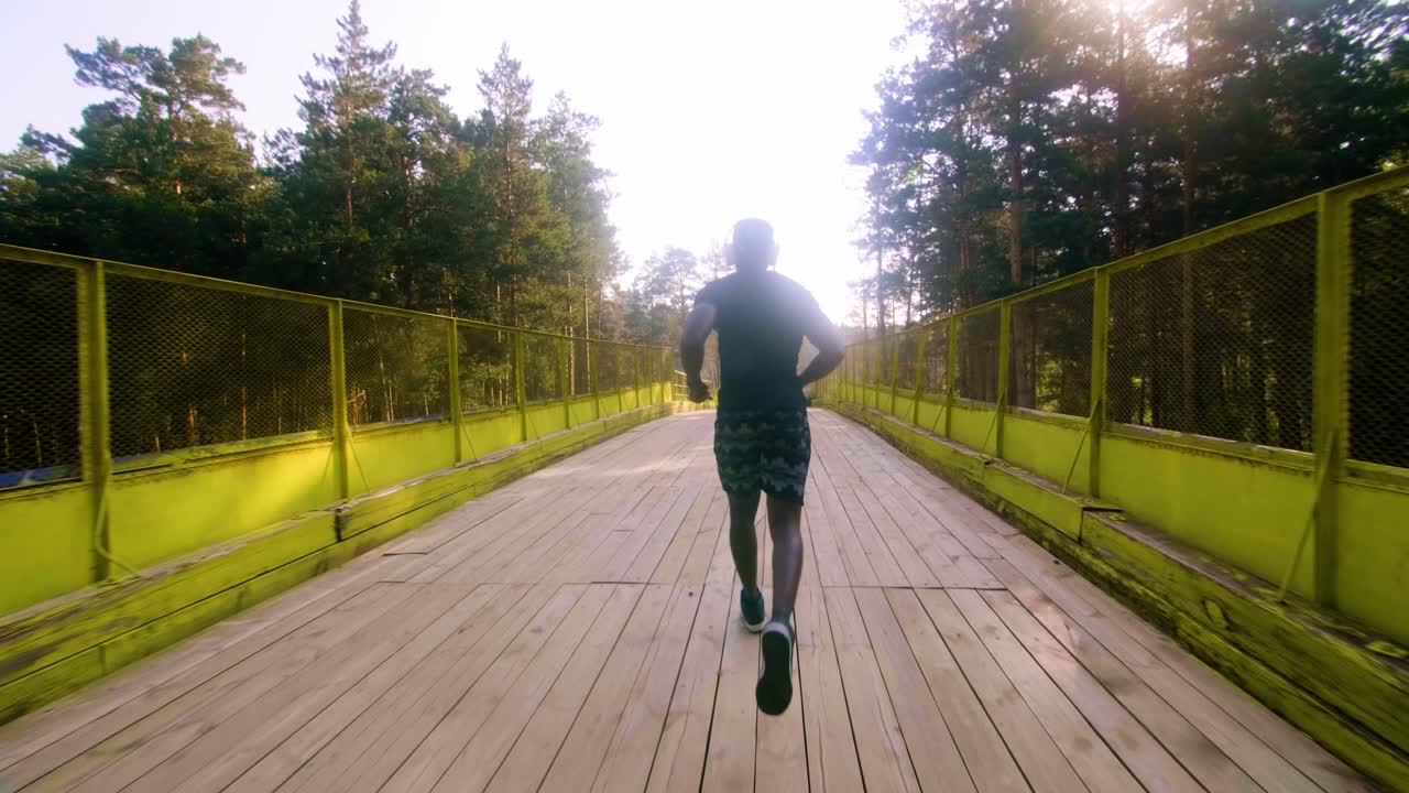 Man Running on a Wooden Bridge Through a Forest
