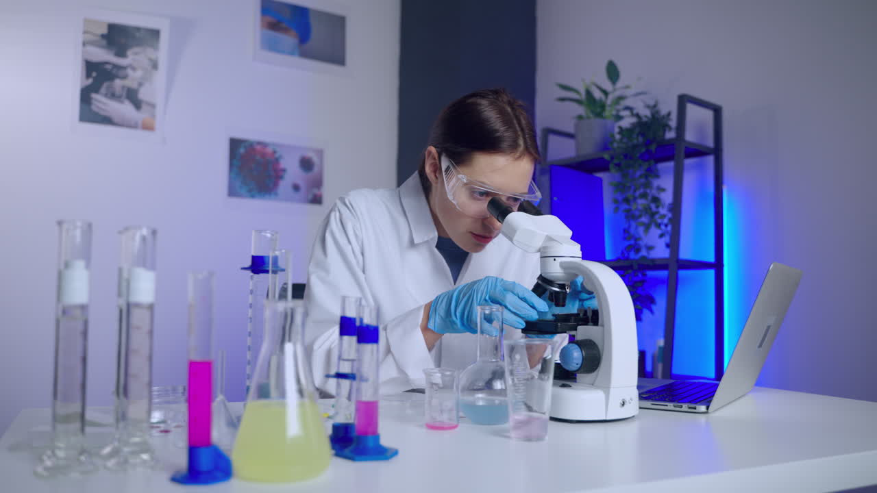 científico que utiliza el microscopio en un entorno de laboratorio