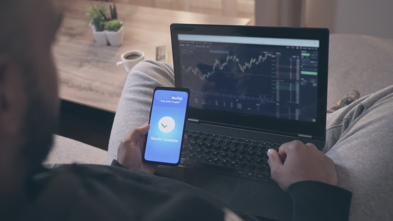 hombre usando una computadora portátil y un teléfono inteligente en el comercio de criptomonedas