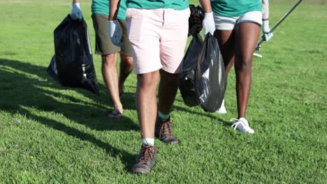 low section of volunteers with garbage bags and rakes