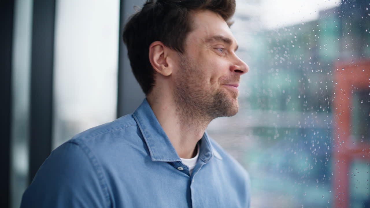 Smiling businessman finish call looking through window at city view closeup