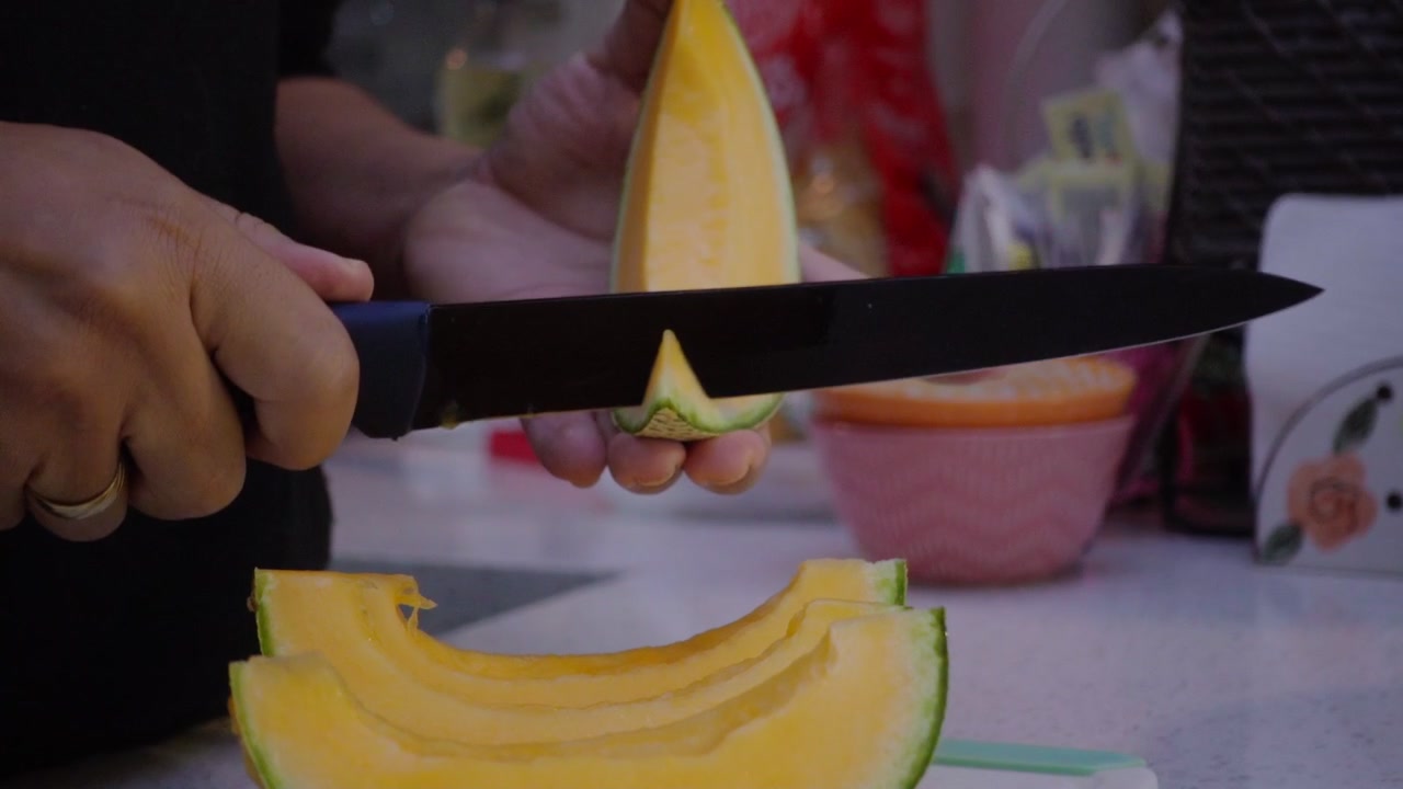 Melón cortado en rodajas, mano con cuchillo cortando porciones de melón