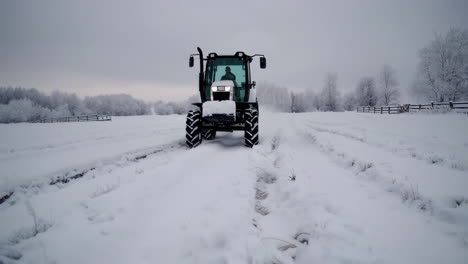 tractor plowing snow in a winter field