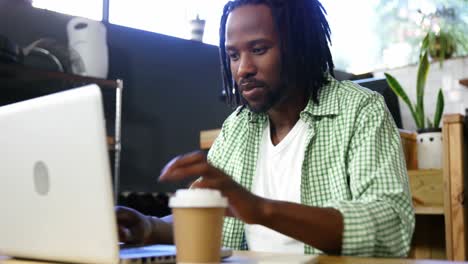 Man-using-laptop-while-having-coffee