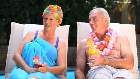 Pareja-De-Ancianos-Relajándose-Cerca-De-La-Piscina.