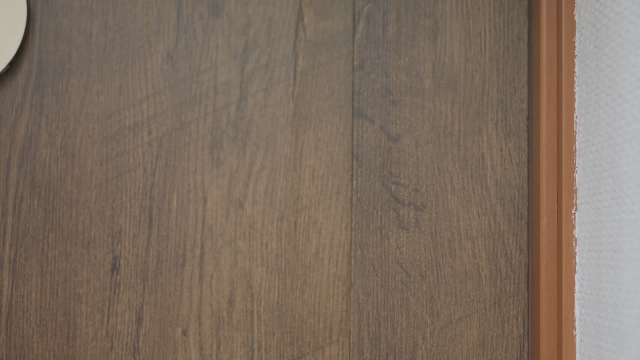 Close up of female hand in white knitted sweater knocking twice on wooden door in calm hallway as guide prepares to open door for session, showing gesture of arrival and request for entry