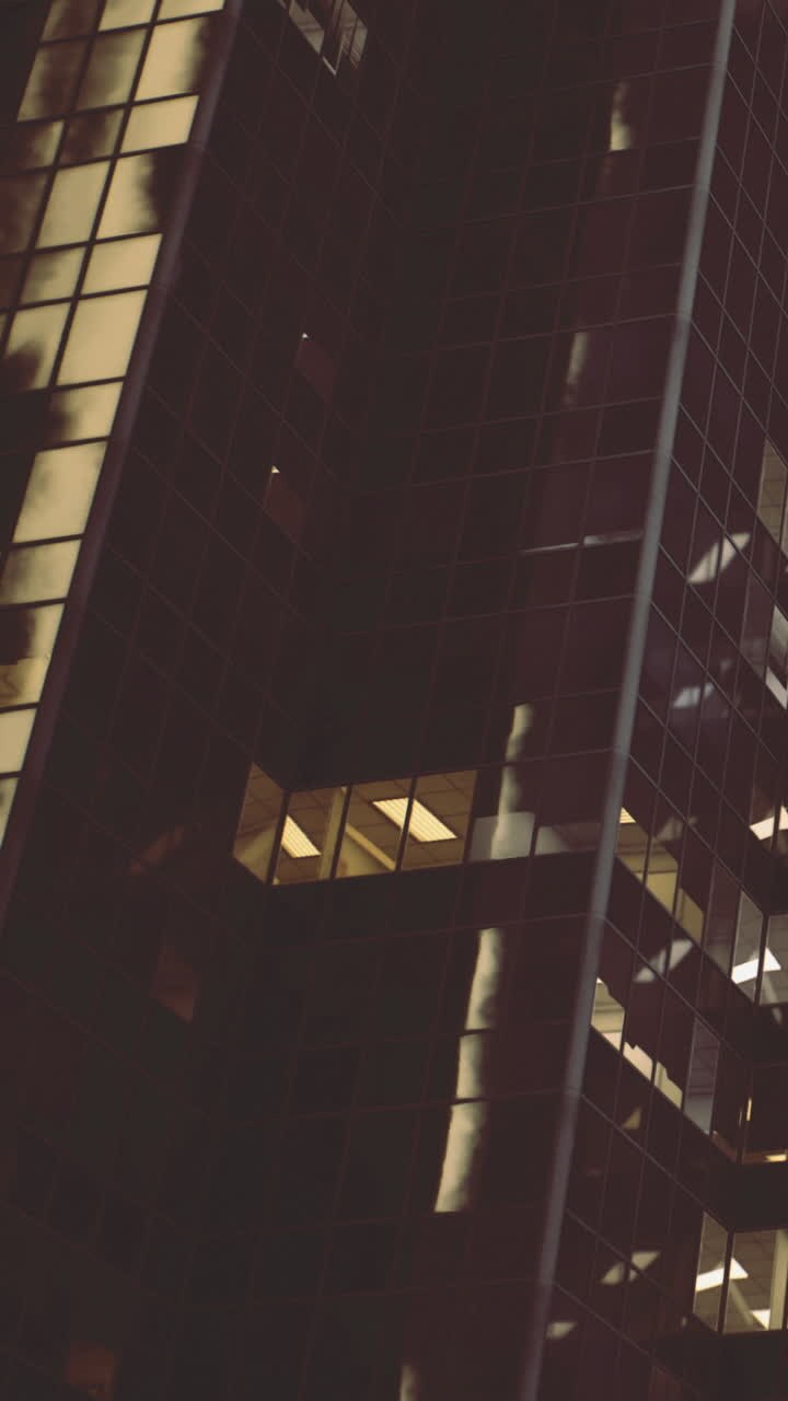 Luzes de edifícios brilham à noite no horizonte de uma cidade.