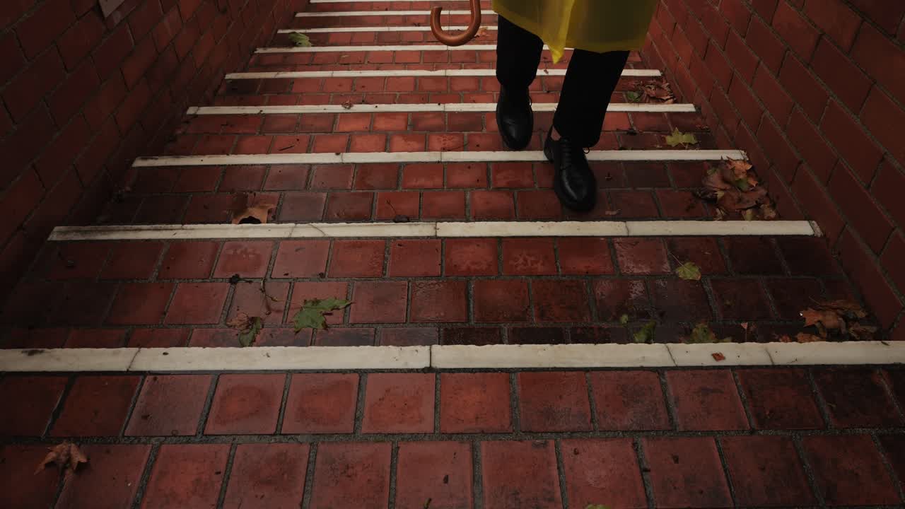 Business man tourist person with umbrella and raincoat on rainy european city street, lights reflecting, walking in Barcelona or Amsterdam during the rain