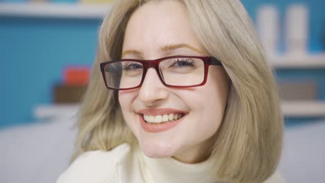 una joven feliz con gafas sonriendo, sintiéndose positiva, alegre.