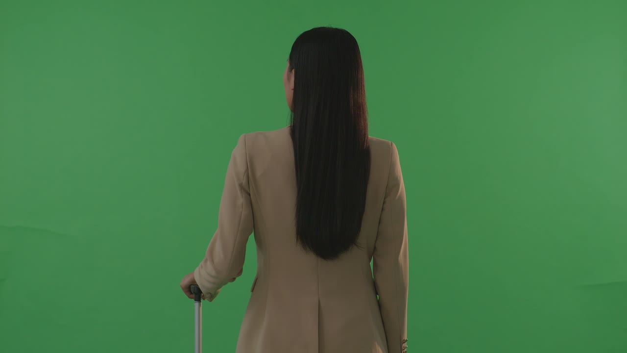 뒷면 아시아 사업가 여성 여행자 짐을 들고 녹색 스크린 배경 스튜디오에 서서 해가 지는 시간
