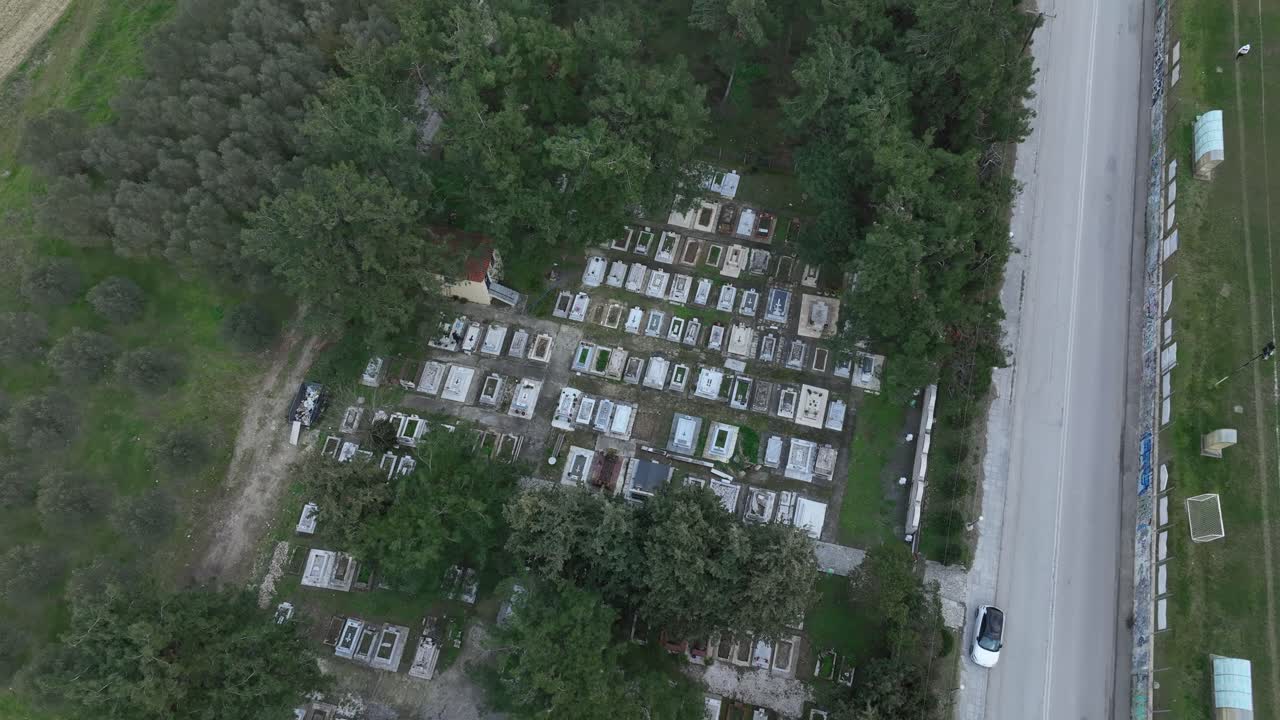 Tilt down over small abandoned cemetery with view of old tombs