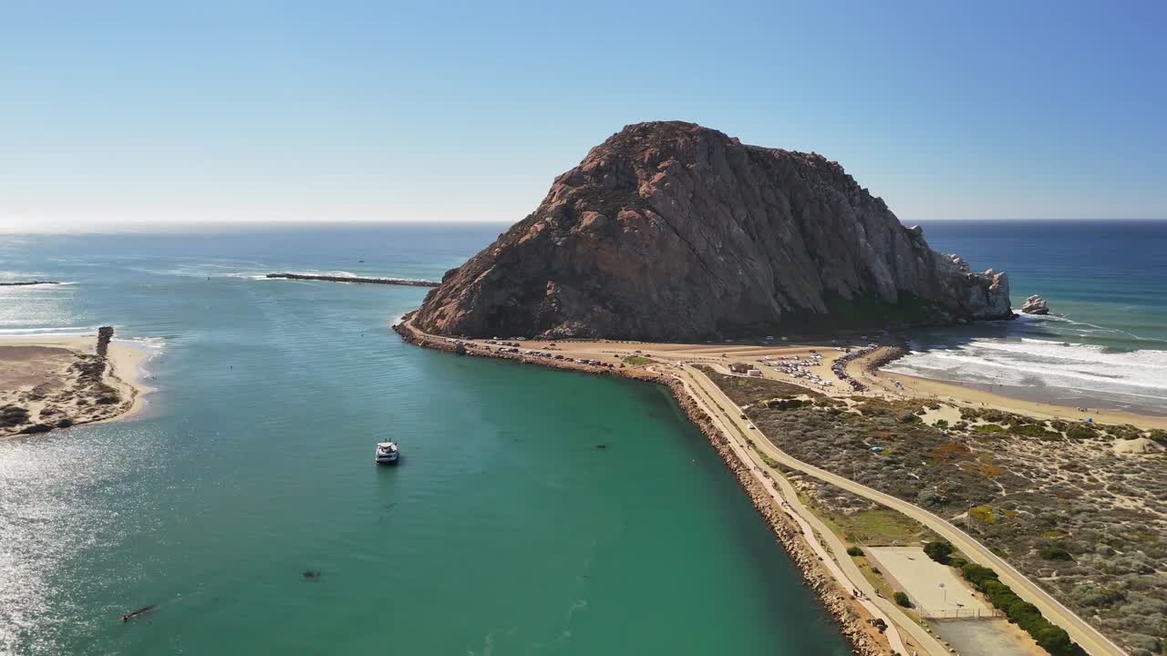 Large incoming waves create rhythmic patterns as the drone tracks along the coast