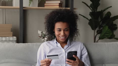 woman using card and smartphone paying for services on internet