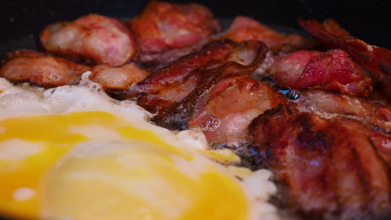 Frying crispy bacon and an egg in a pan