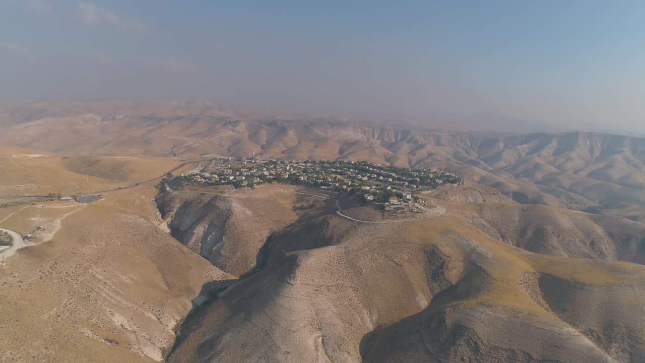 Insediamento ebraico nel deserto della Giudea e della Samaria in Israele. Vista aerea con drone di case di villaggio su cime di montagne. Vita mediterranea all'aperto in coesistenza.