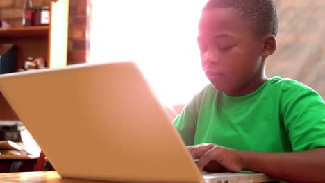 little boy using laptop in classroom