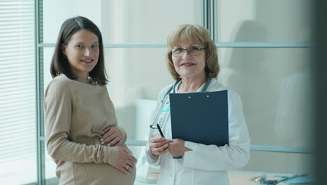 portrait of pregnant woman and doctor in clinic