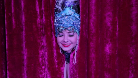 showgirl peeking through red curtains