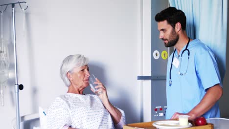 nurse giving medicines to female senior patient