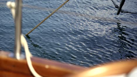 isolated view of the waves on the water from a sailboat anchored in port