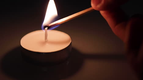 a small candle being lit with a match