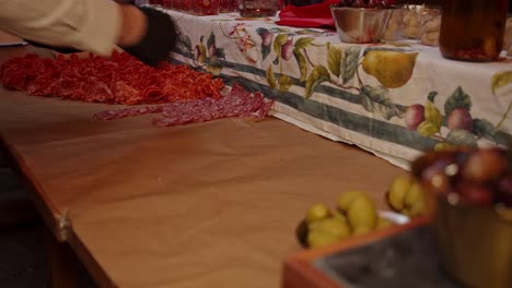 Time-lapse-of-chef-laying-out-salami-Napoli-meat-snacks-on-outdoor-catering-table-at-night