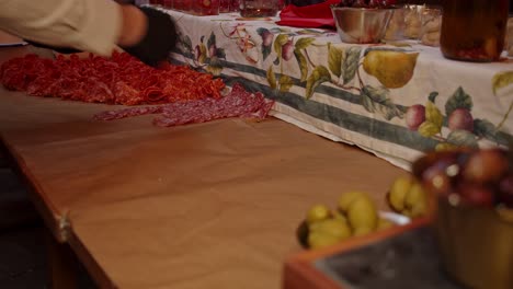 time lapse of chef laying out salami napoli meat snacks on outdoor catering table at night