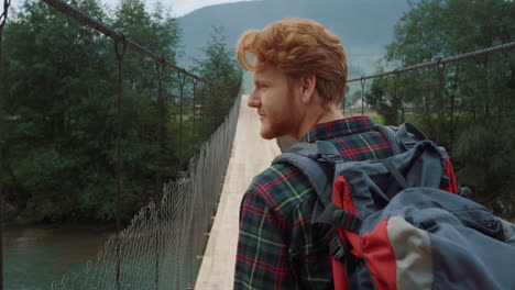 el turista disfruta del paisaje de las montañas. el viajero feliz lleva mochila en el autostop.