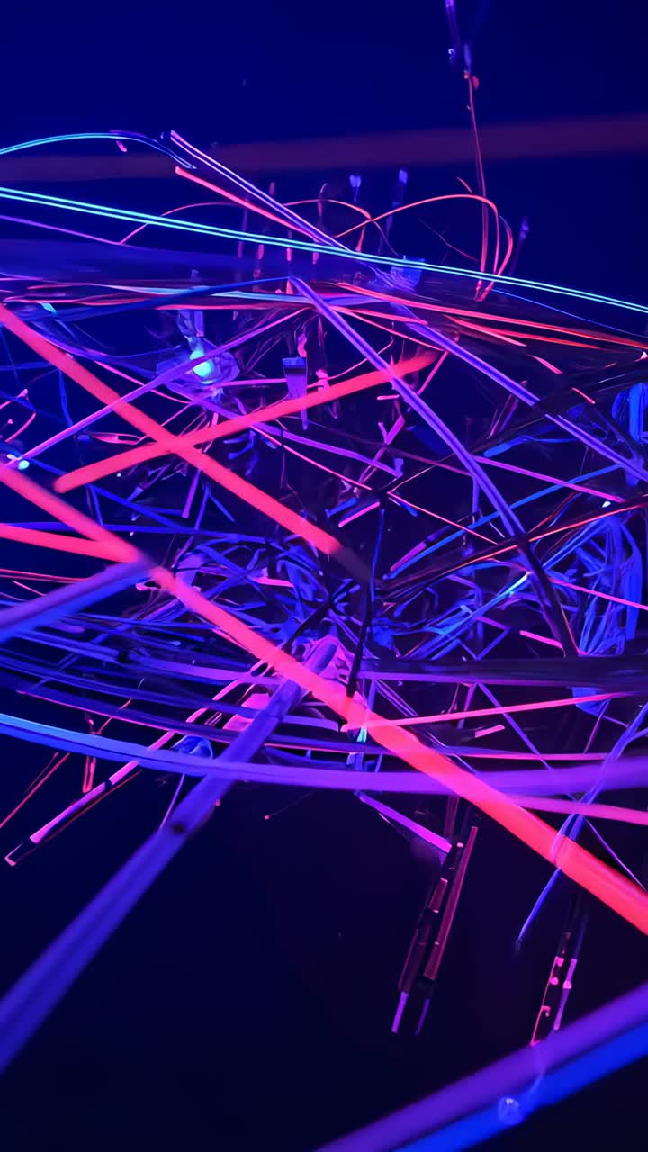 Vertical video: Starting camera tilting down on rotating rods at gallery revealing LED nodes