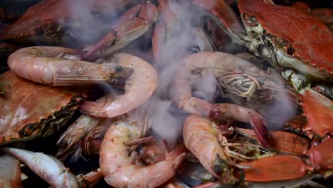 grupo de cangrejos azules humeantes y camarones grandes en pila