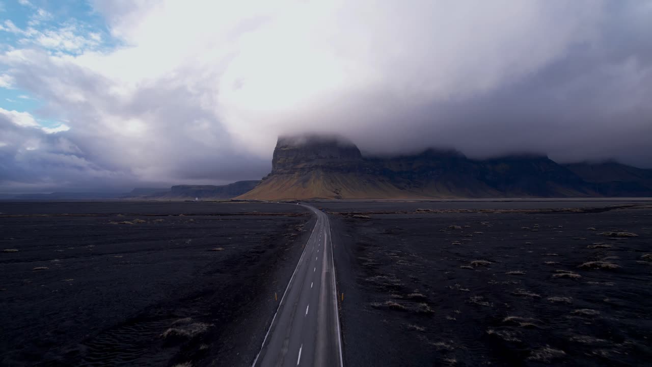 Secluded Icelandic Highway with Dramatic cloud cover over cliffs