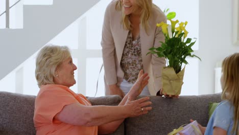 Mujer-Dando-Ramo-De-Flores-A-Su-Madre-En-La-Sala-De-Estar-4k