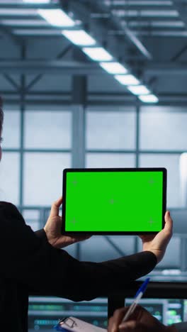 vertical video data center colleagues using green screen chroma key device to monitor facility