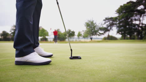 close-up de uma jogadora de golfe colocando a bola no verde