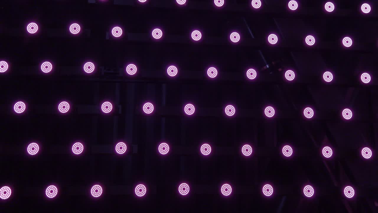 ряд небольших круглых розовых красных мигающих светодиодных огней на стене