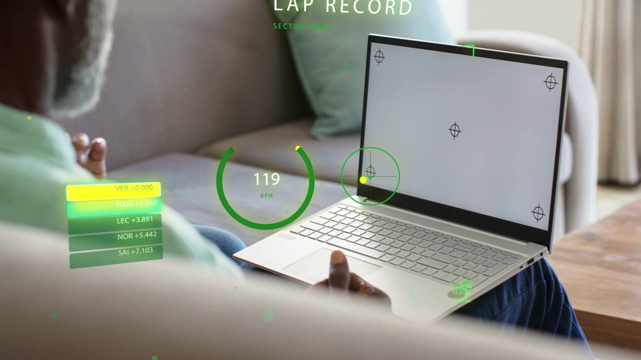Mature man pointing and gesturing on laptop on couch, activating HUD lap gauge and sports telemetry