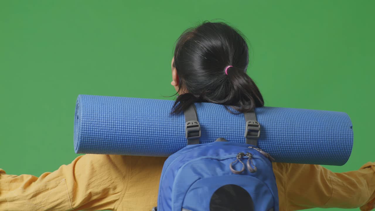 mujer con mochila y estera de yoga