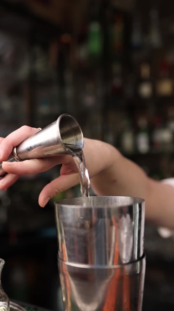 Bartender Derramando Líquido de um Dosador em uma Coqueteleira