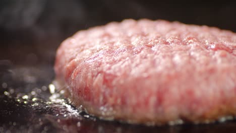 raw beef burger is fried with hot steam.