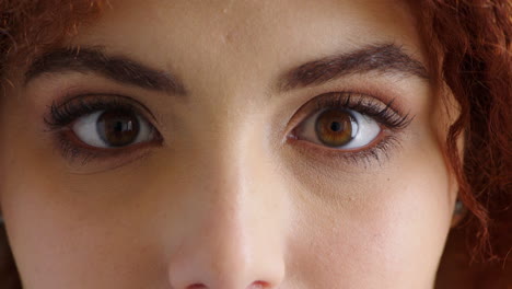 closeup face of a woman opening her eyes wide