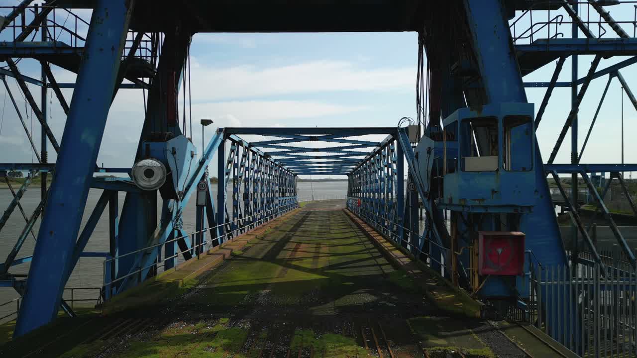 volando bajo una grúa abandonada y en un puente oxidado en muelles abandonados en los muelles de fleetwood, lancashire, reino unido